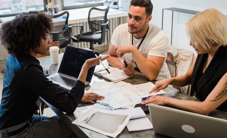Diverse startup team brainstorming and planning together around a table, representing early-stage business planning