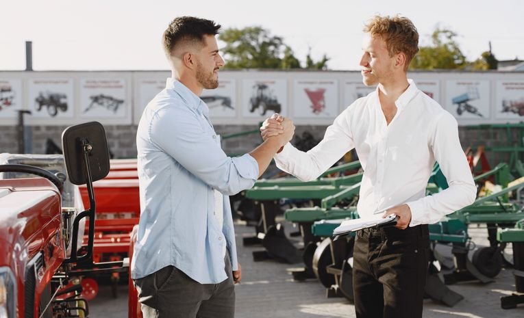 Salesperson and customer shaking hands, representing successfully overcoming a sales objection to close a deal