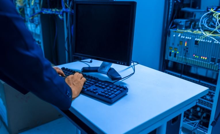 IT professional managing network systems in a server room, representing IT support options for small businesses