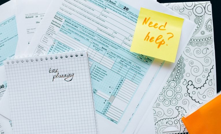 Person reviewing UK business paperwork and a calculator, representing comparing sole trader versus limited company structures