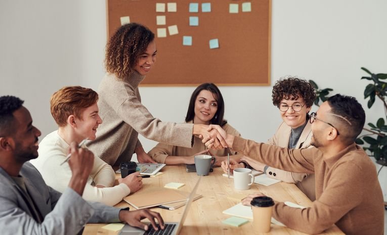 Small business team smiling together in the workplace, representing a strong employer brand that attracts and retains talent